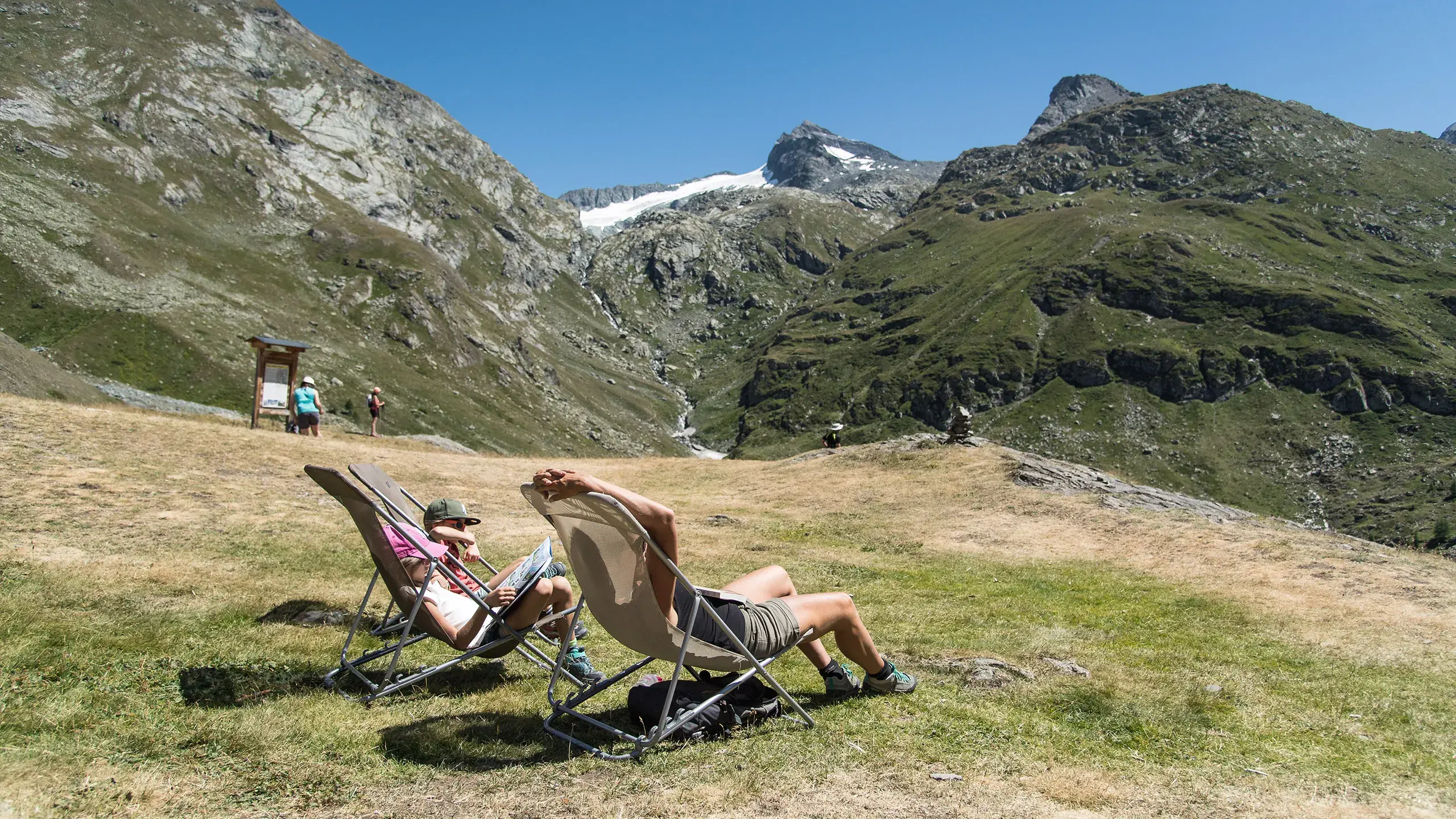 Deux personnes se reposent dans des chaises longues en altitude en Haute Maurienne
