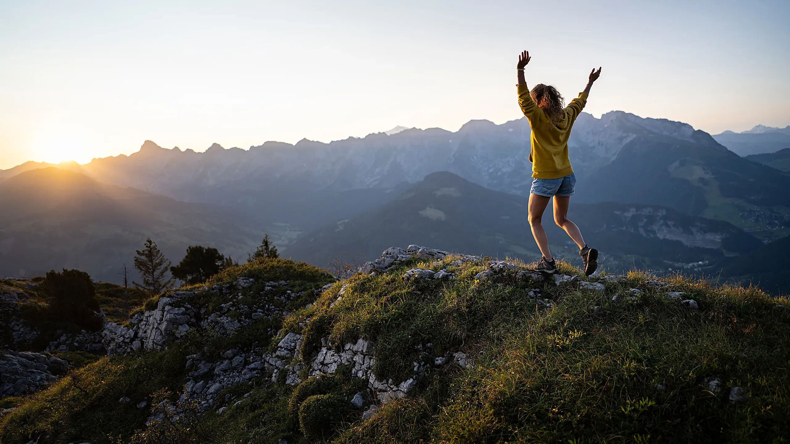 Femme sur le sommet d'une montagne dans la chaîne des Aravis durant le coucher de soleil