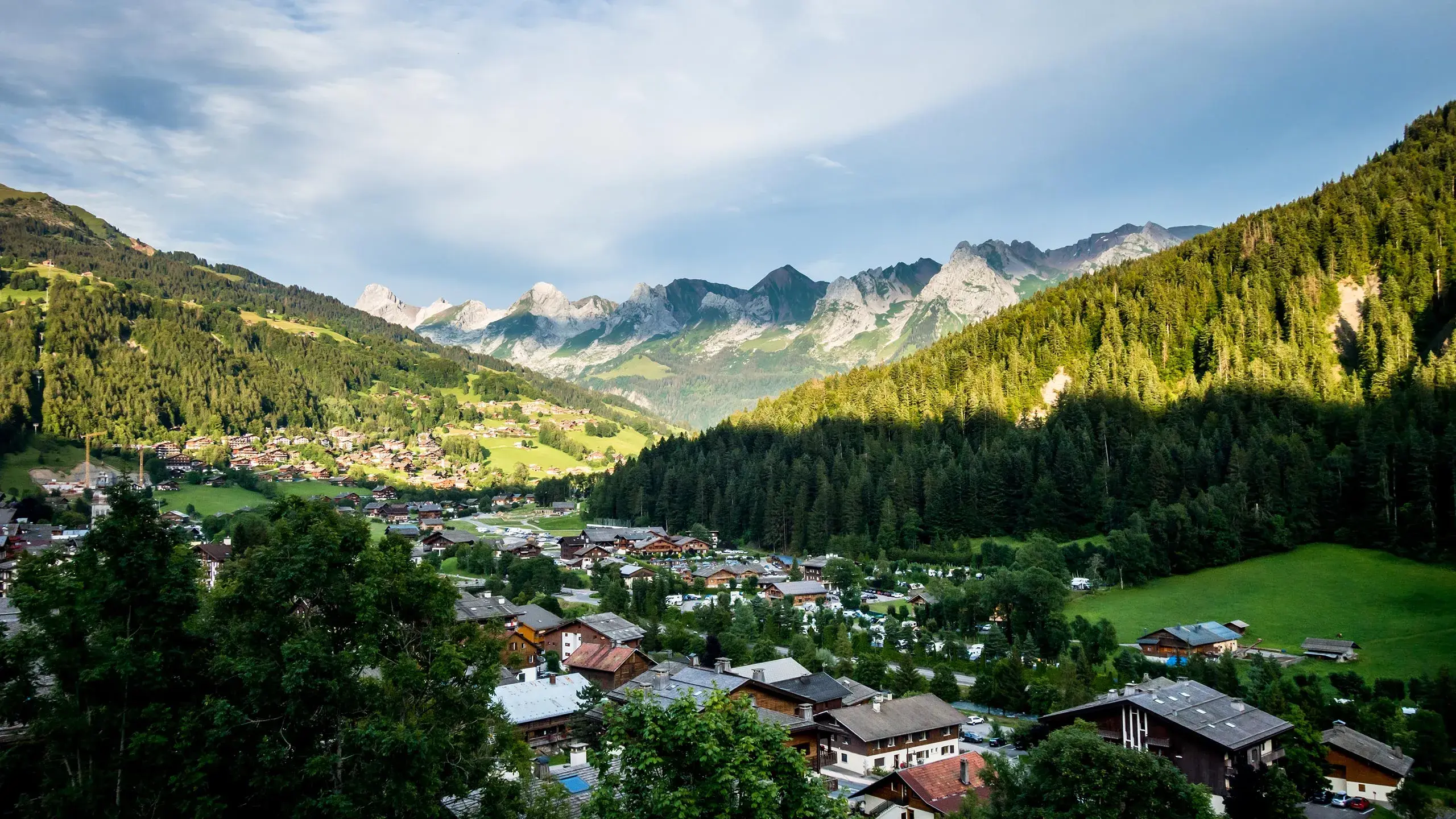 Vue sur le village du Grand-Bornand en été avec la chaine des Aravis en arrière plan