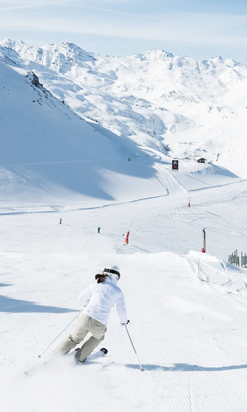 Deux personnes dévalent les pistes de Méribel en ski alpin