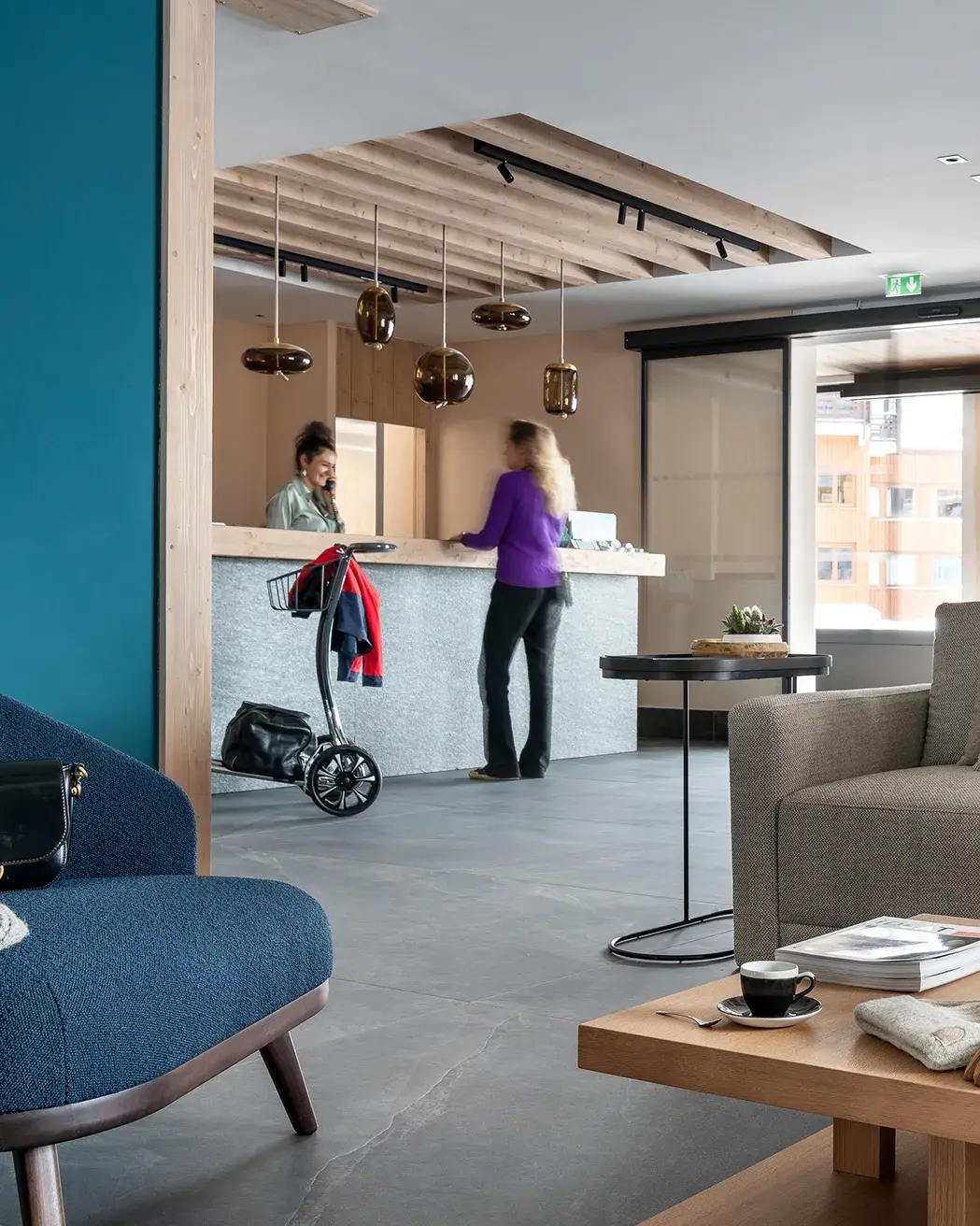 Des personnes sont au comptoir de la réception de la résidence Manaka à La Plagne