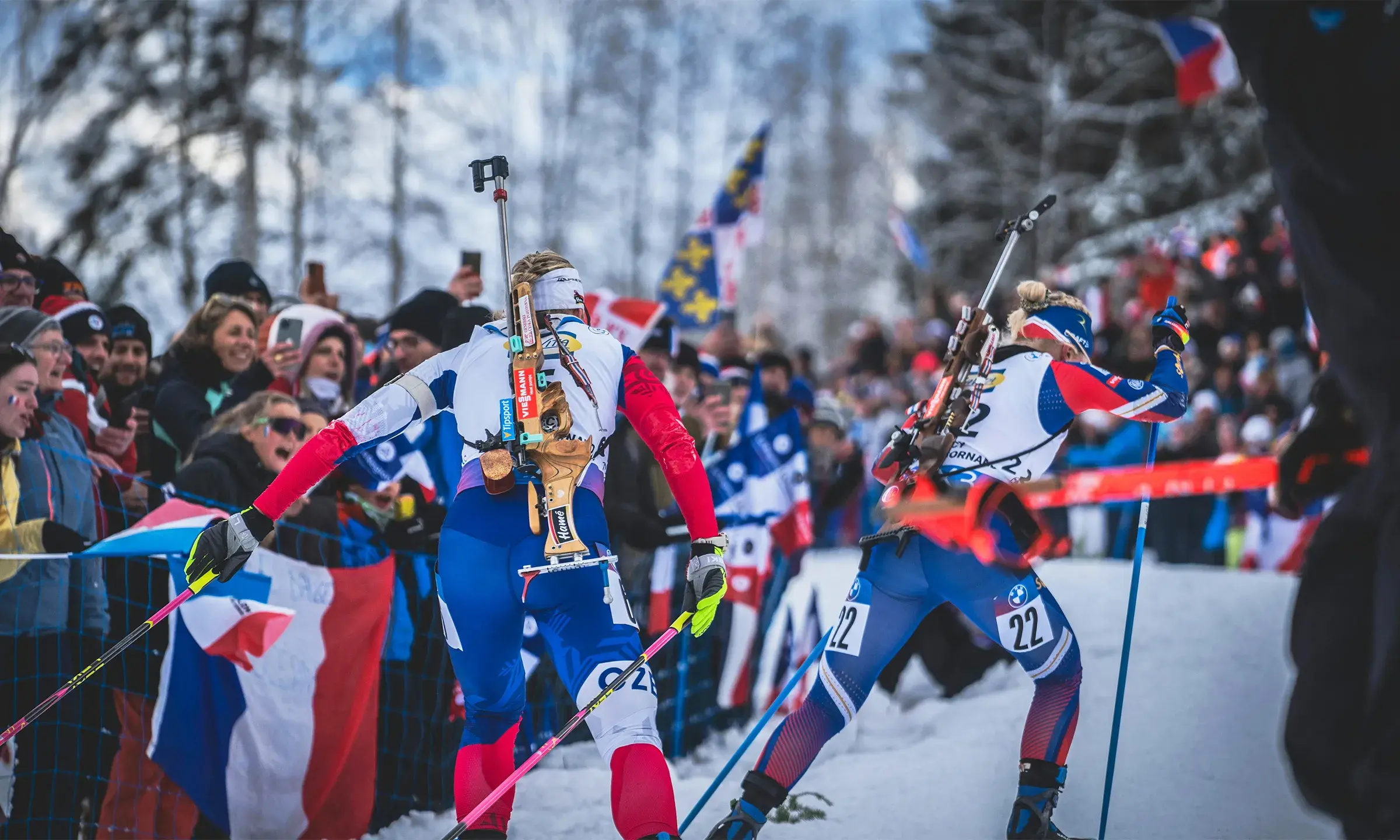 Compétition de biathlon avec des spectateurs encourageant les athlètes en bord de piste