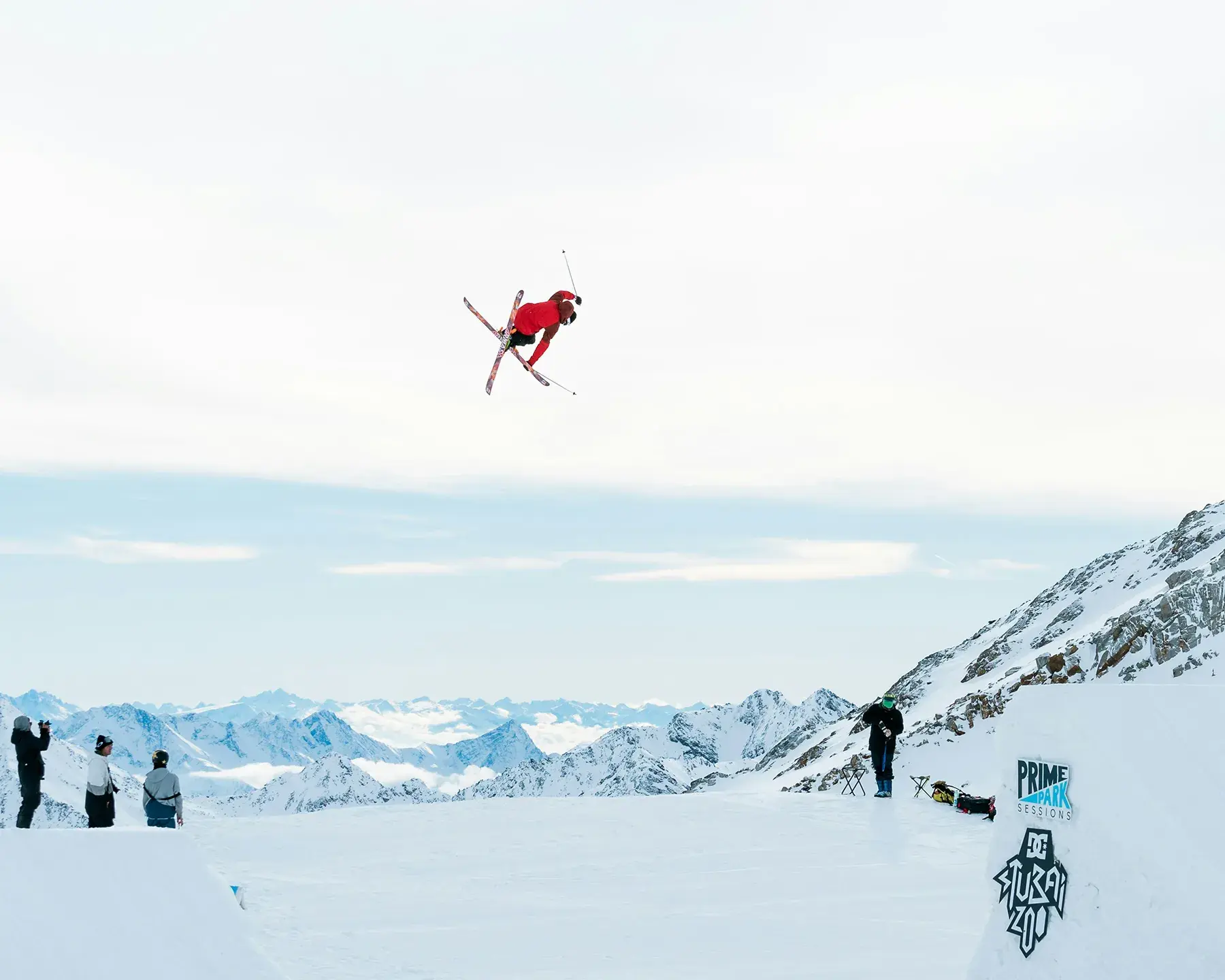 Un personne est en train de faire un saut en ski depuis le tremplin d'un snowpark