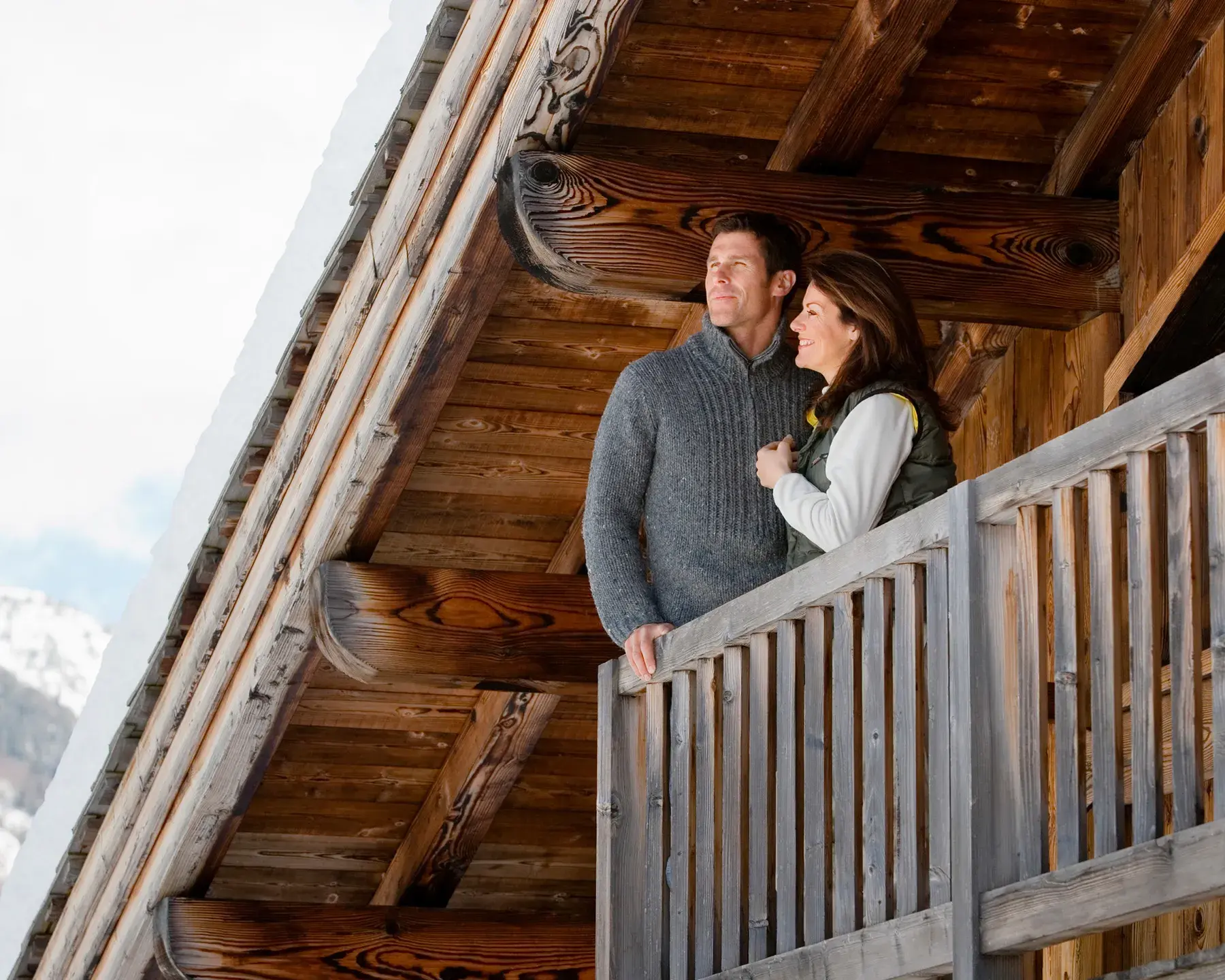 couple sur le balcon d'un chalet admirant la vue